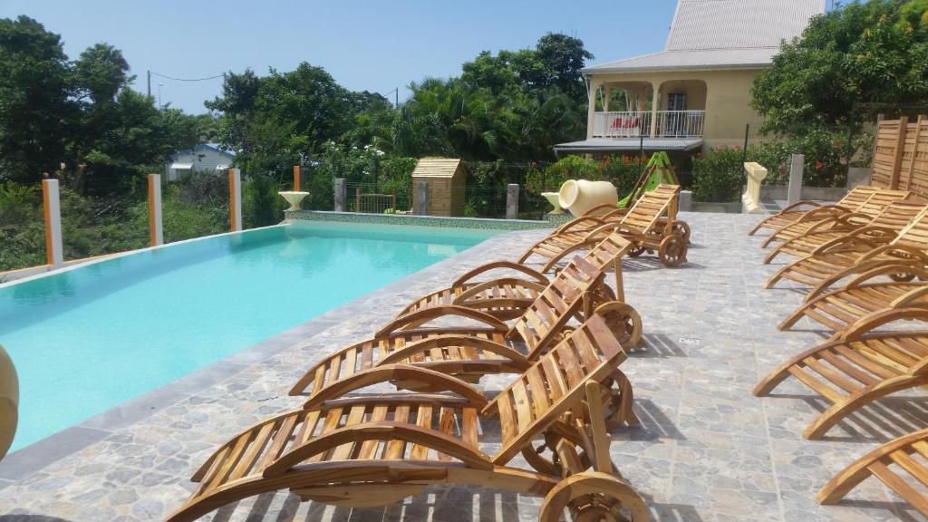a group of chairs sitting next to a swimming pool at Résidence SIMONA in Deshaies