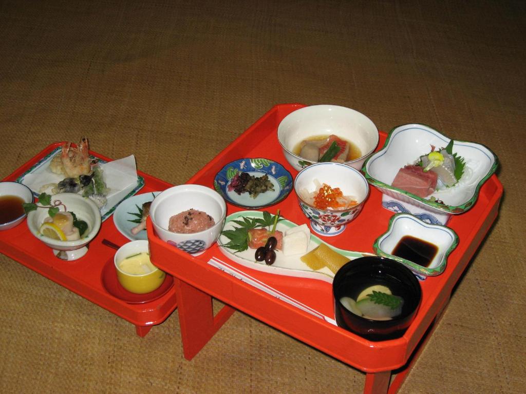 a red tray with dishes of food on it at Gyokuzoin in Heguri