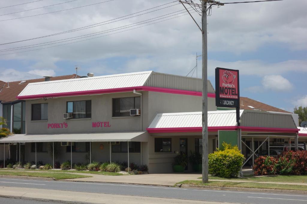 
a red and white building with a sign on the side of the building at Porkys Motel in Rockhampton
