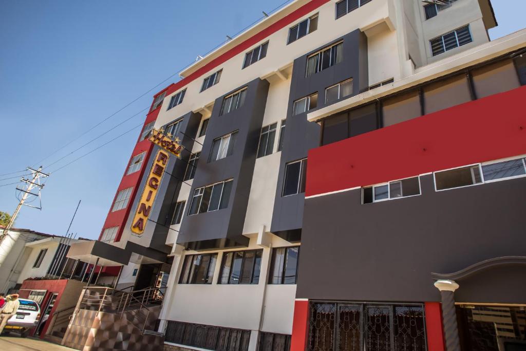 een hoog gebouw met een rood en wit bij Hotel Regina in Cochabamba