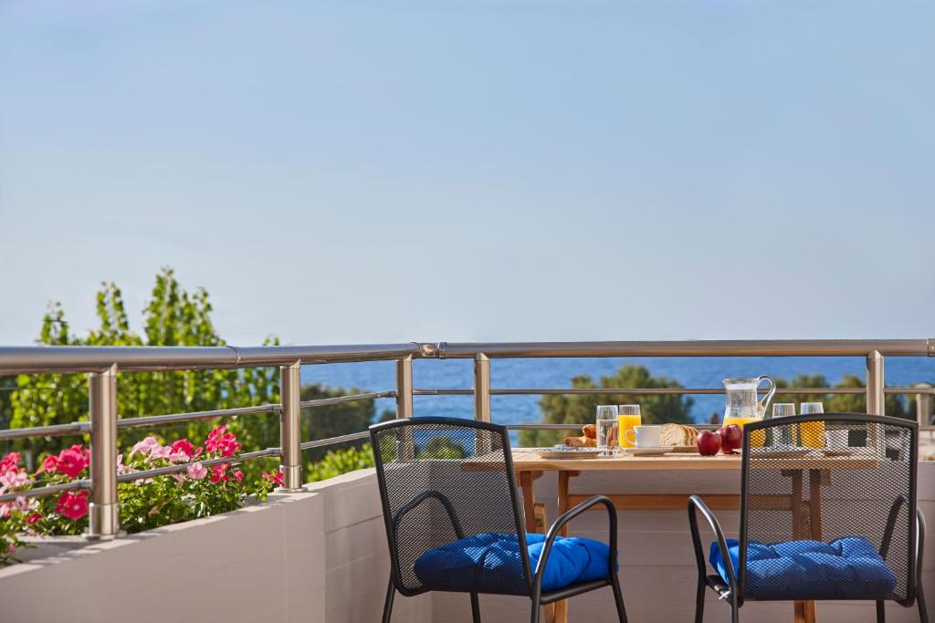 un tavolo e sedie su un balcone con vista sull'acqua di La Vita Classica a Chania