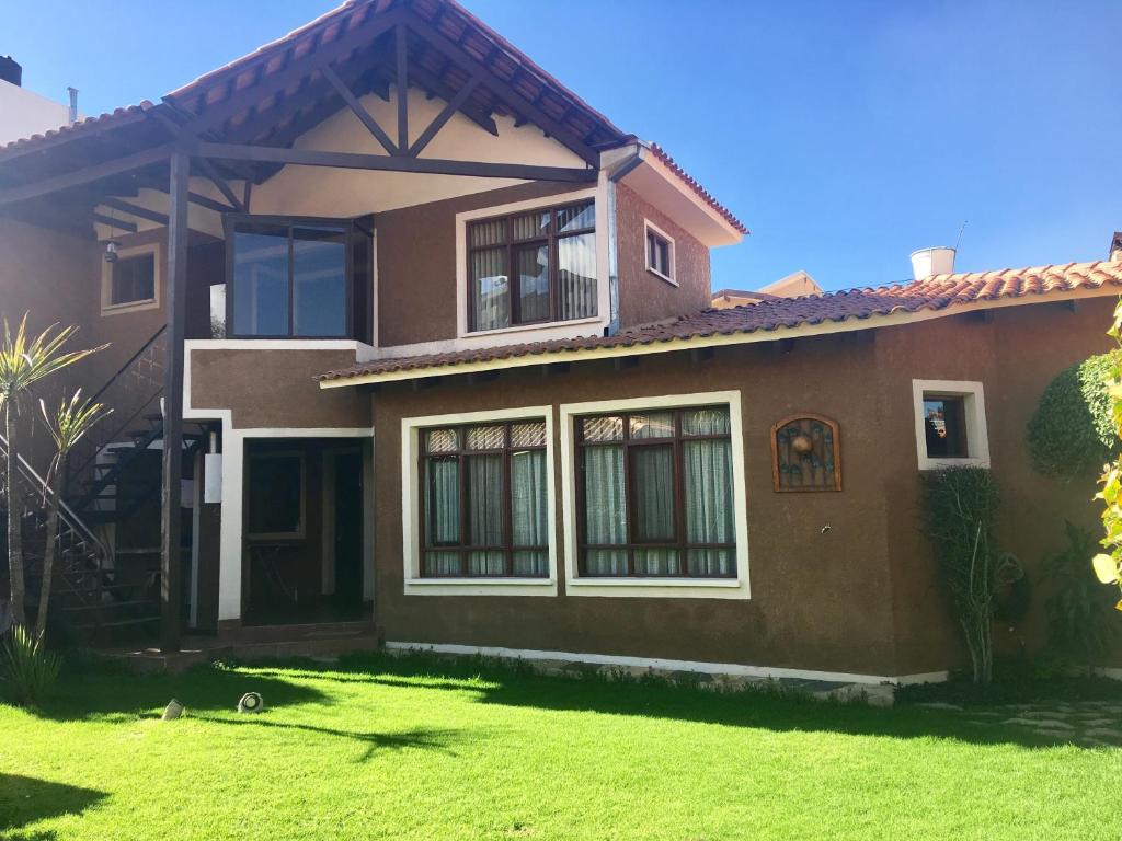 une maison avec une pelouse verte devant elle dans l'établissement Apartamento con jardin, à Cochabamba