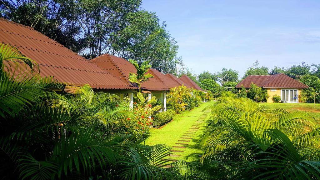 a house with a garden in front of it at CharPoot Cottage Khao Lak in Khao Lak