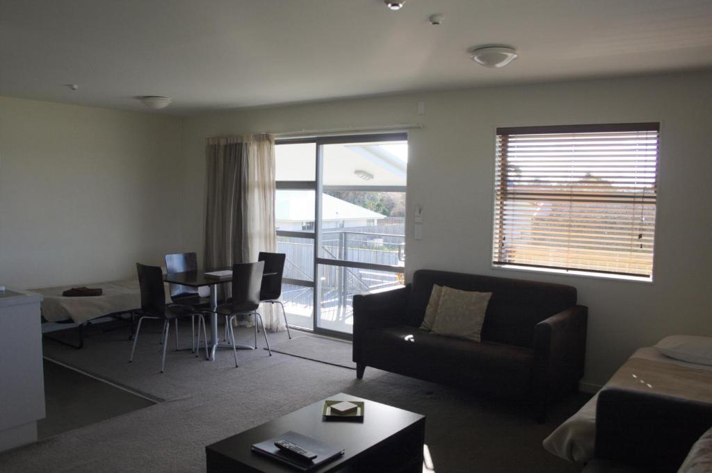 a living room with a couch and a table at Pegasus Gateway Motels & Apartments in Rangiora