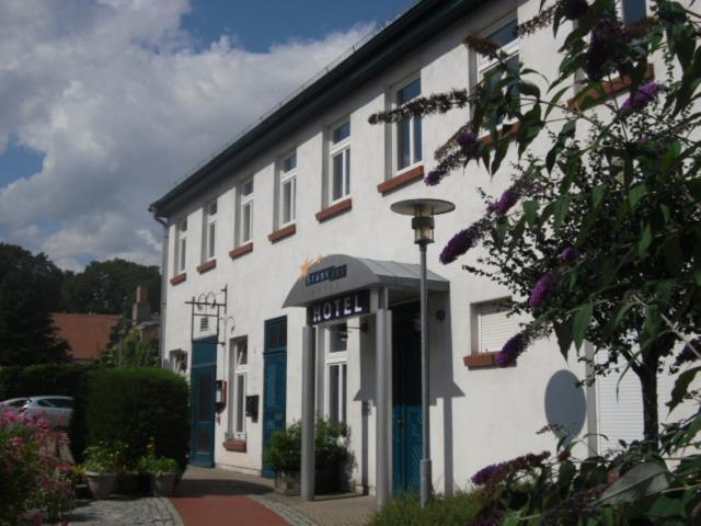 a white building with a sign in front of it at Pension Töpferhof in Tangermünde