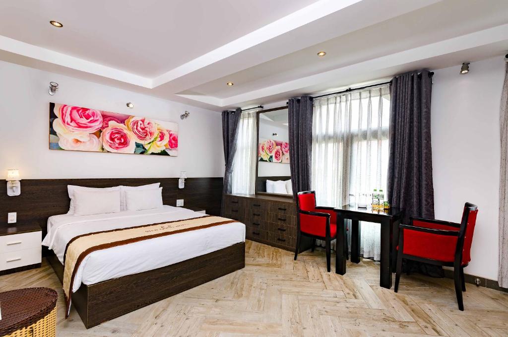 a hotel room with a bed and a desk and a table at Vien Dong Hotel 2 in Ho Chi Minh City