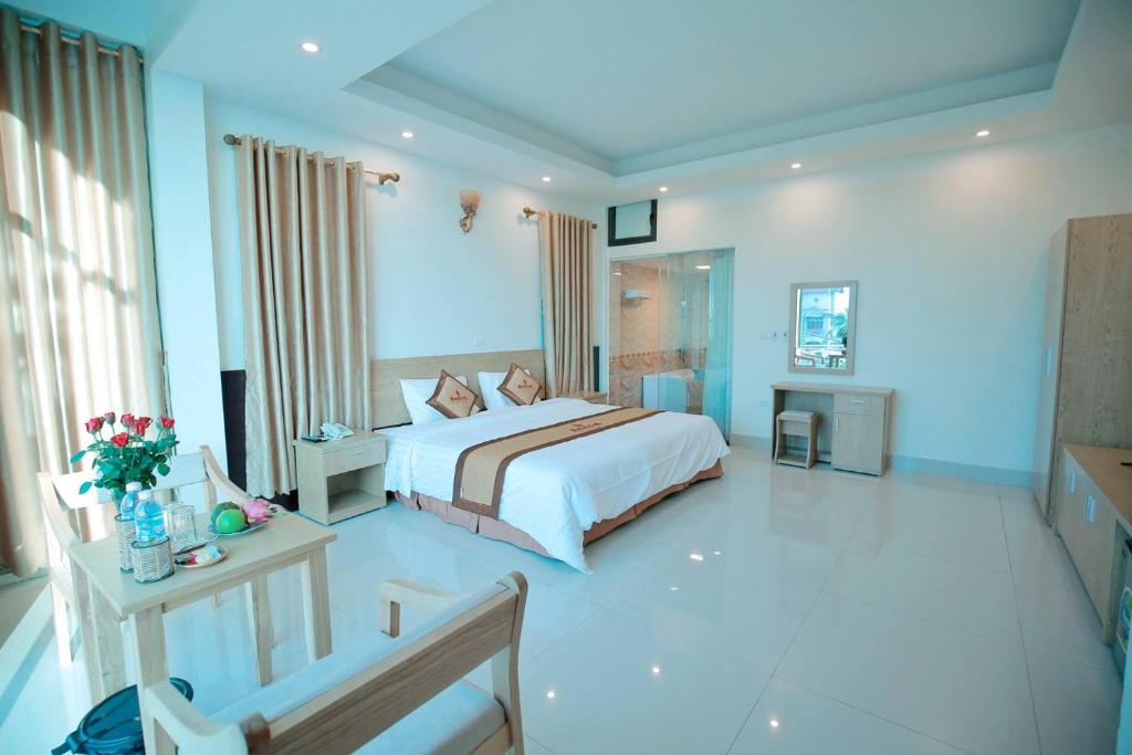 Anova Airport Hotel في Noi Bai: غرفة نوم كبيرة مع سرير وطاولة