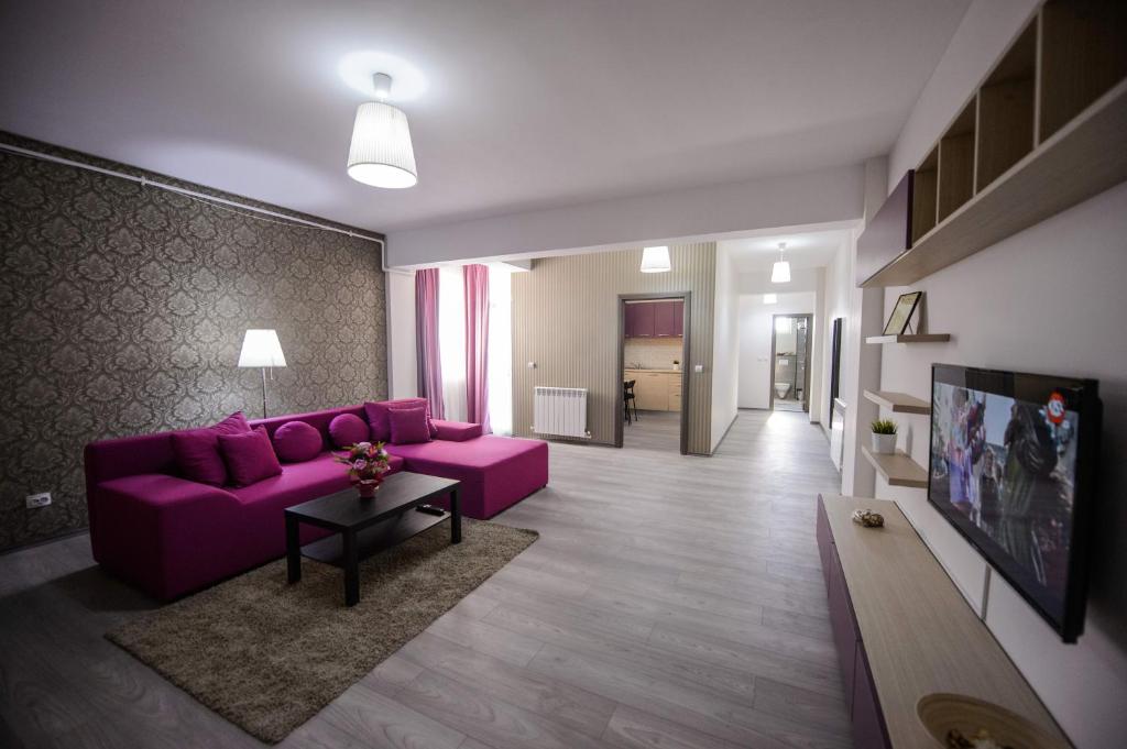 een woonkamer met een paarse bank en een tafel bij Magnum Residence in Mamaia Nord – Năvodari