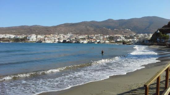a view of a beach with a city in the background at Vassiliki Studios in Andros