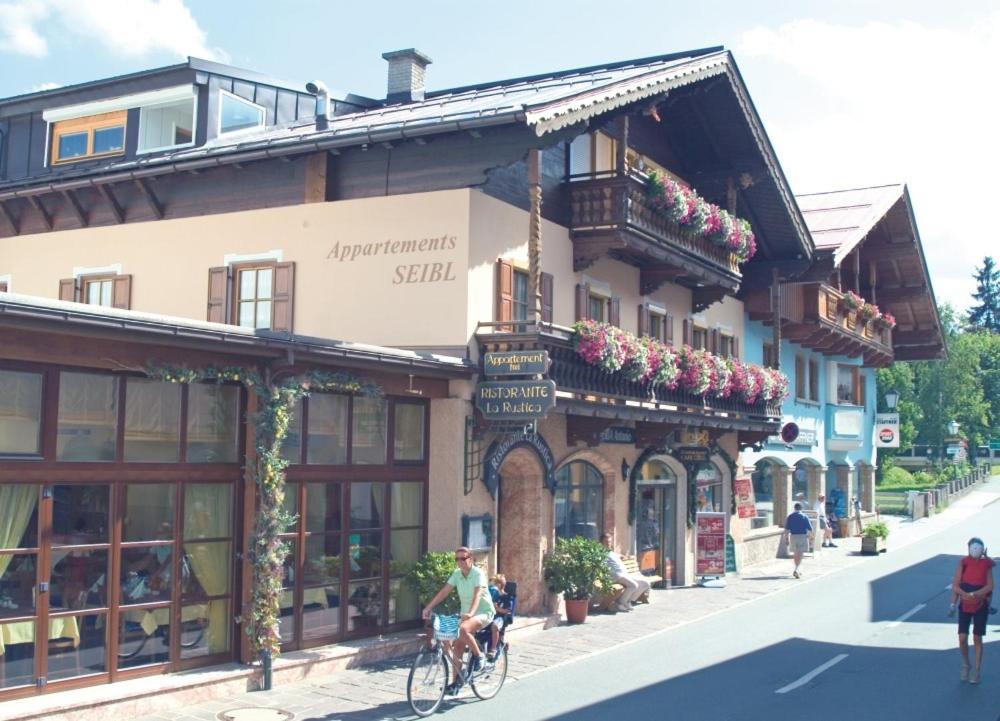 a building with people riding bikes on a street at Appartement Seibl in Sankt Johann in Tirol