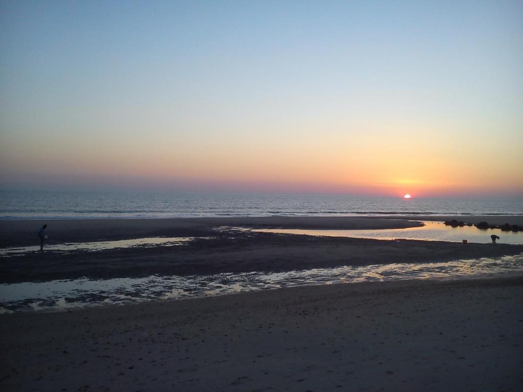 een persoon die bij zonsondergang op het strand staat bij Apartamento Naturaleza Virgen in Matalascañas