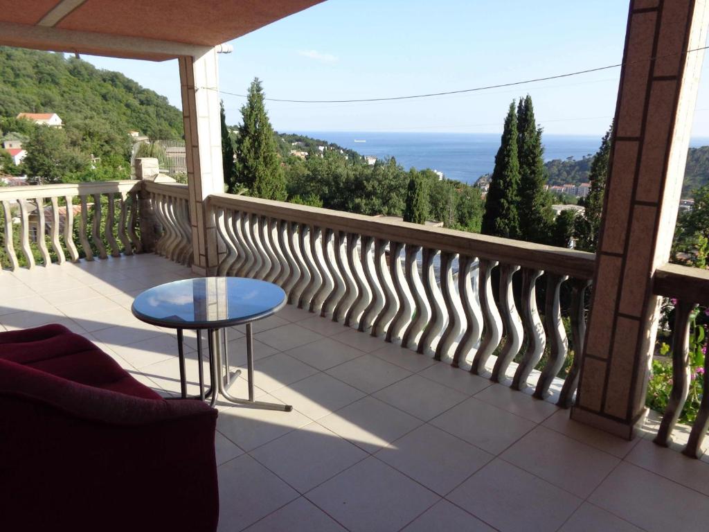 a balcony with a table and a view of the ocean at Guest House Tatyana in Sutomore