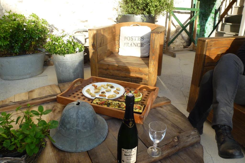 un tavolo con una bottiglia di vino e una pizza di Une Maison en Touraine a Saint-Branchs