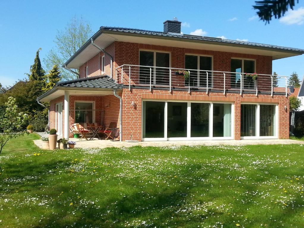 a brick house with a balcony on top of a yard at Ferienwohnung an der Hasenburg in Lüneburg