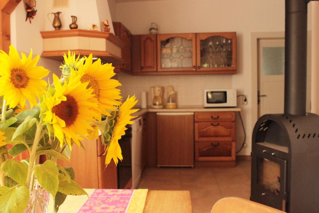 uma cozinha com uma mesa com girassóis e um fogão em Ferienhaus Mühlberg em Radebeul