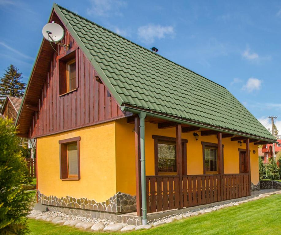 una casa amarilla y naranja con techo verde en Chata Beňušovce, en Liptovský Trnovec