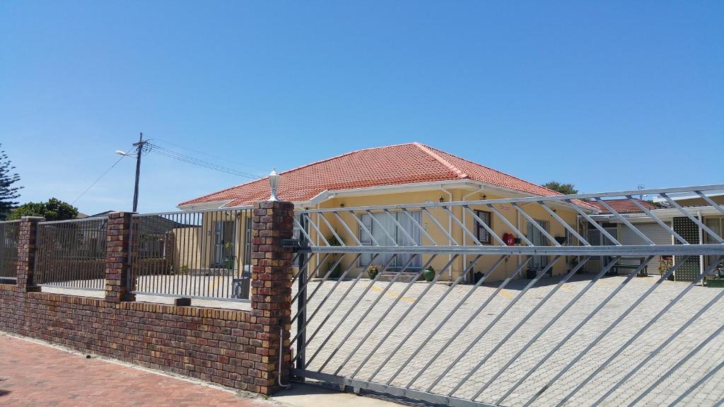 a fence in front of a house at Port Elizabeth Apartment in Port Elizabeth