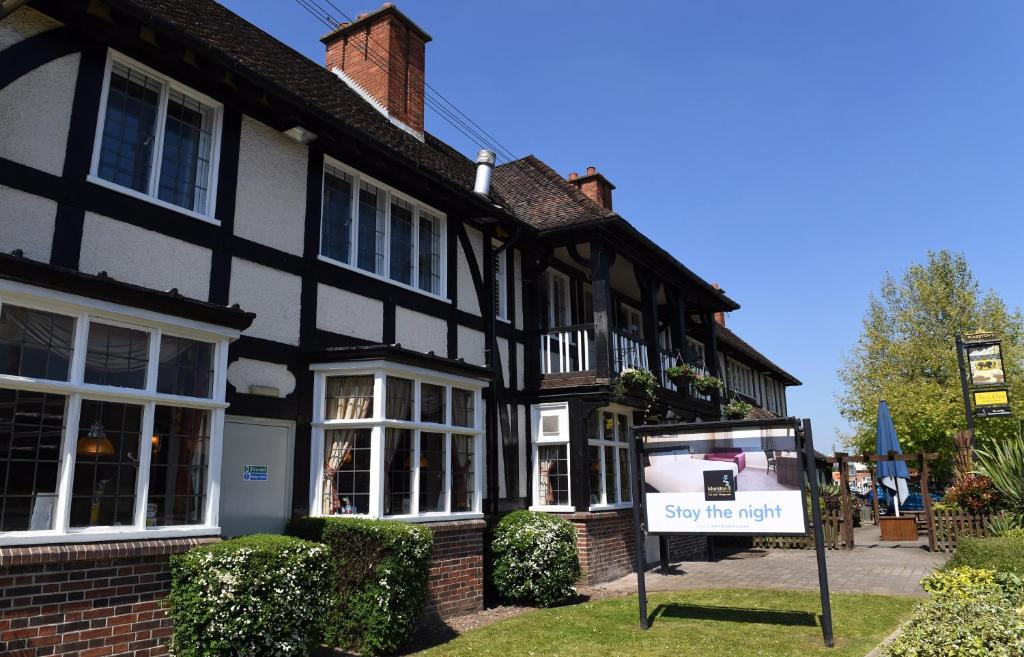 a black and white house with a sign in front of it at Crown, Droitwich by Marston's Inns in Droitwich