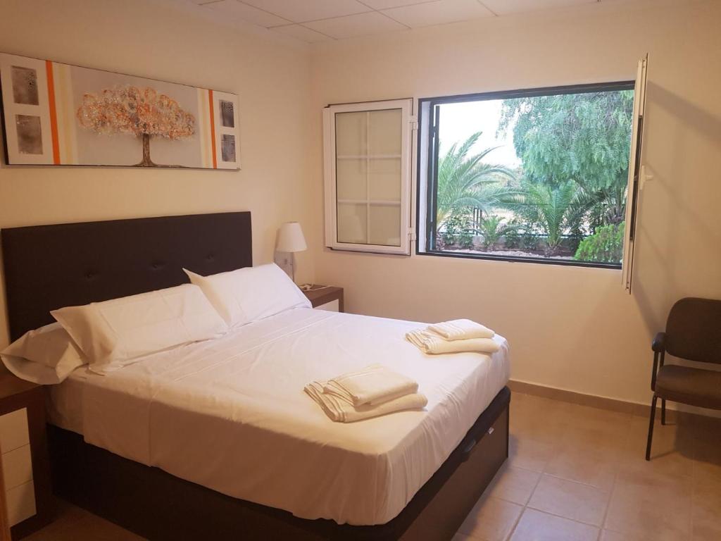 a bedroom with a bed with two towels on it at Chalet Bacarot in Alicante