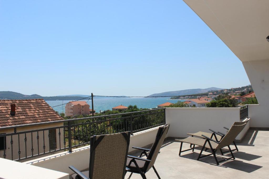 een balkon met stoelen en uitzicht op het water bij Apartment Luce in Trogir