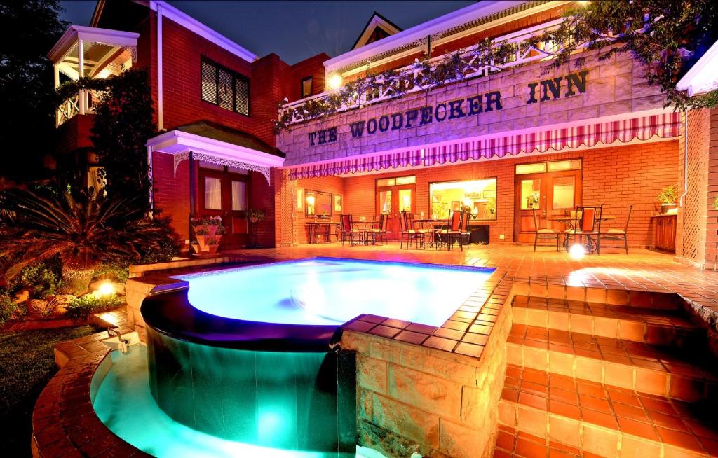 a swimming pool in the courtyard of a building at The Woodpecker Inn in Pretoria