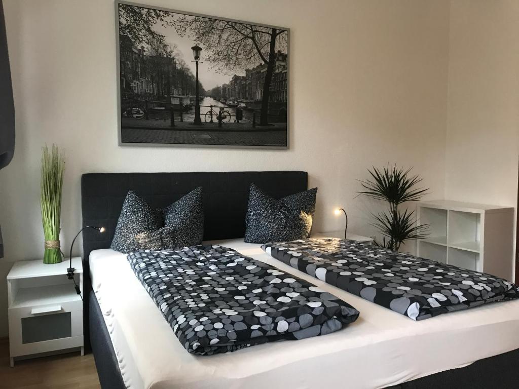 Schlafzimmer mit einem großen Bett mit einem schwarzen Kopfteil in der Unterkunft Citywohnungen Halle Saale in Halle an der Saale