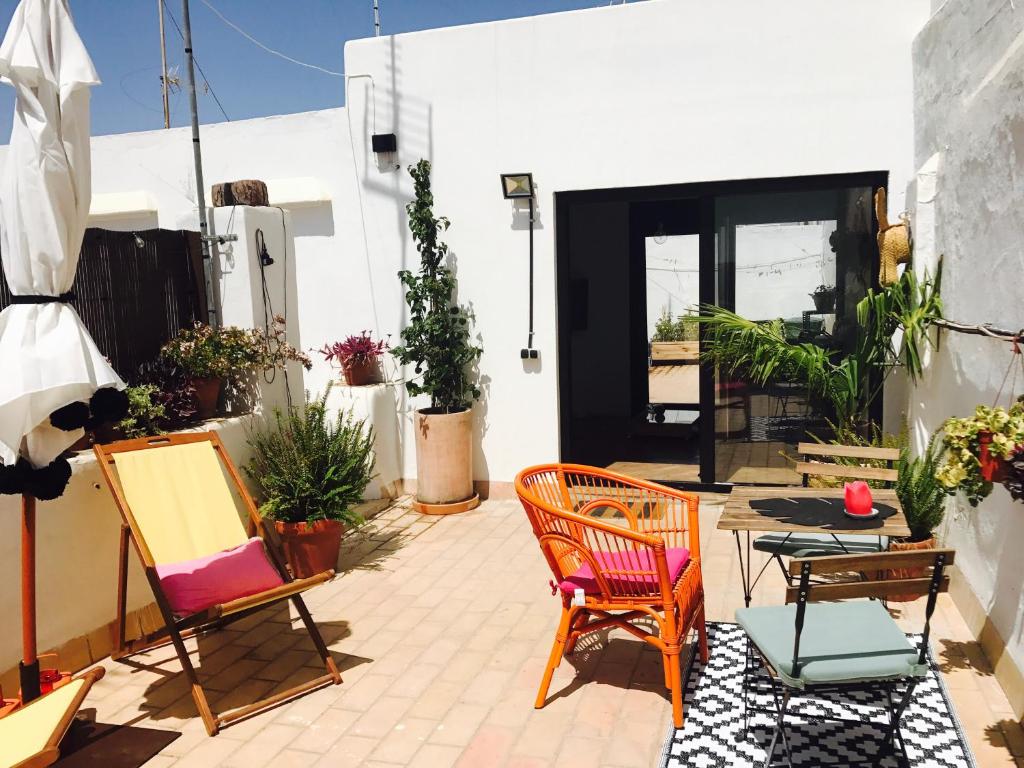 een patio met kleurrijke stoelen en een zwarte deur bij Ático Falla in Cádiz