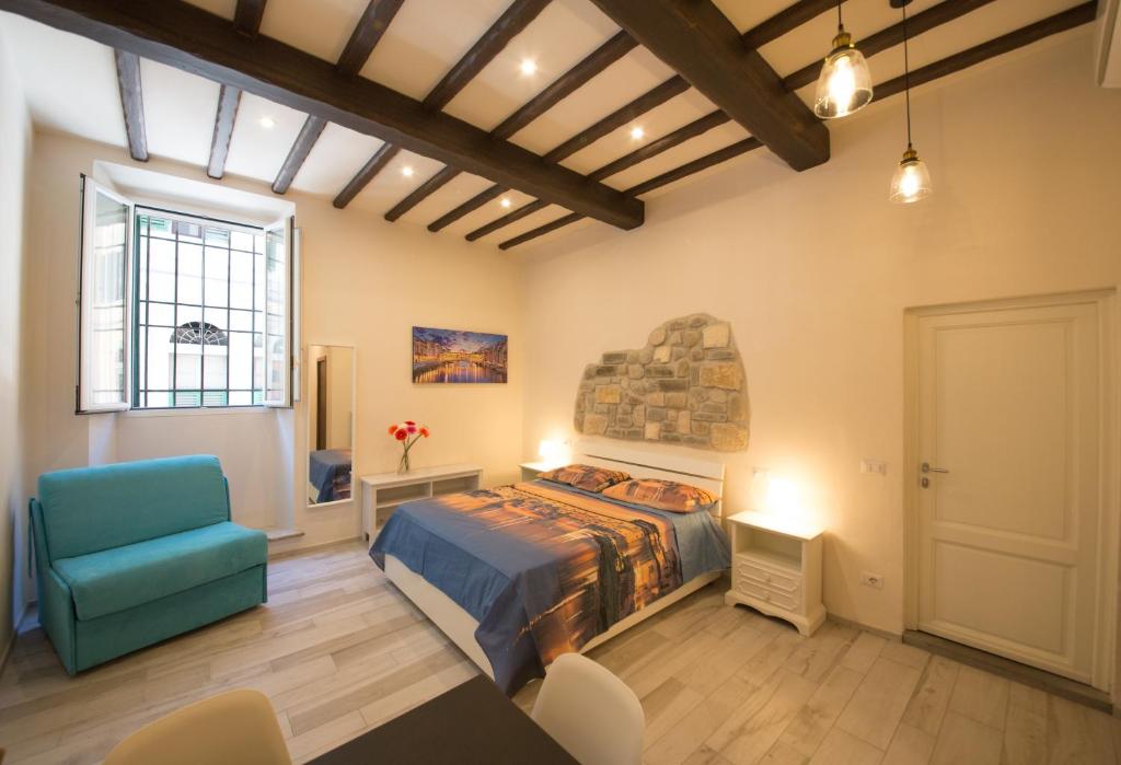 una camera con letto e sedia blu di Visit Florentia Apartment a Firenze