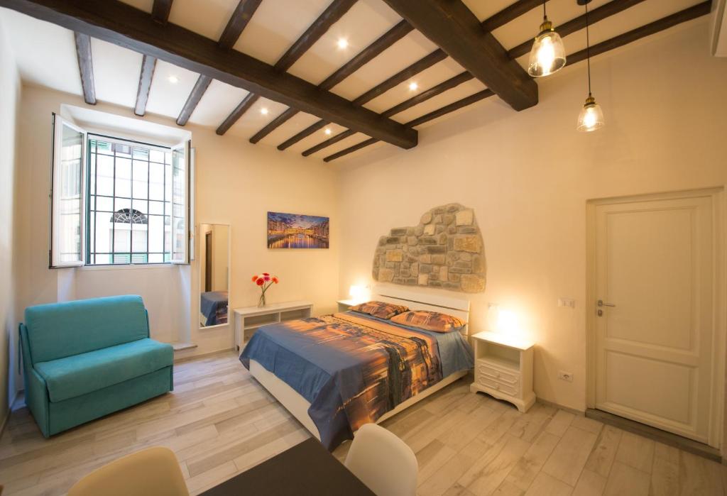 a bedroom with a bed and a blue chair at Visit Florentia Apartment in Florence