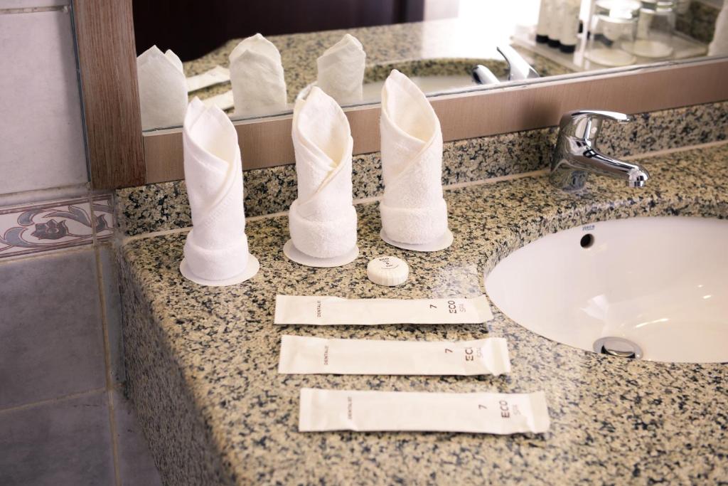 a bathroom counter with white pairs of shoes on it at Saja Al Madinah in Al Madinah