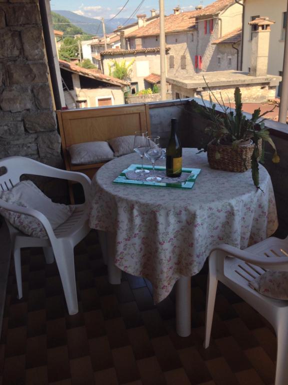 una mesa con una botella de vino y copas en el balcón en B&B Casa Lisa, en Miane