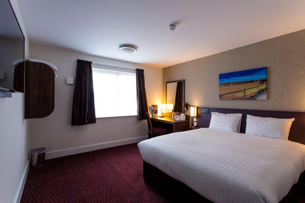 a hotel room with a large bed and a window at Sessile Oak, Llanelli by Marston's Inns in Llanelli