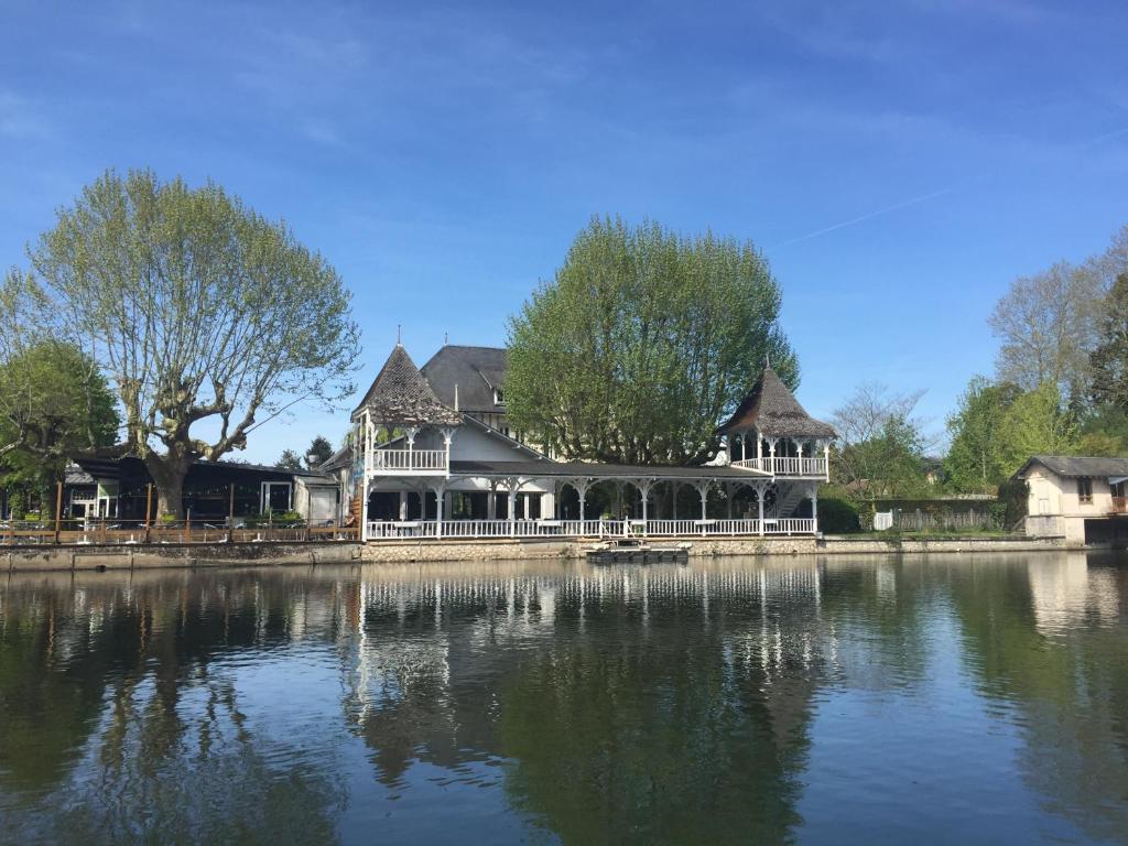 a large house sitting on top of a lake at Hotel Restaurant Pavillon Bleu in Olivet