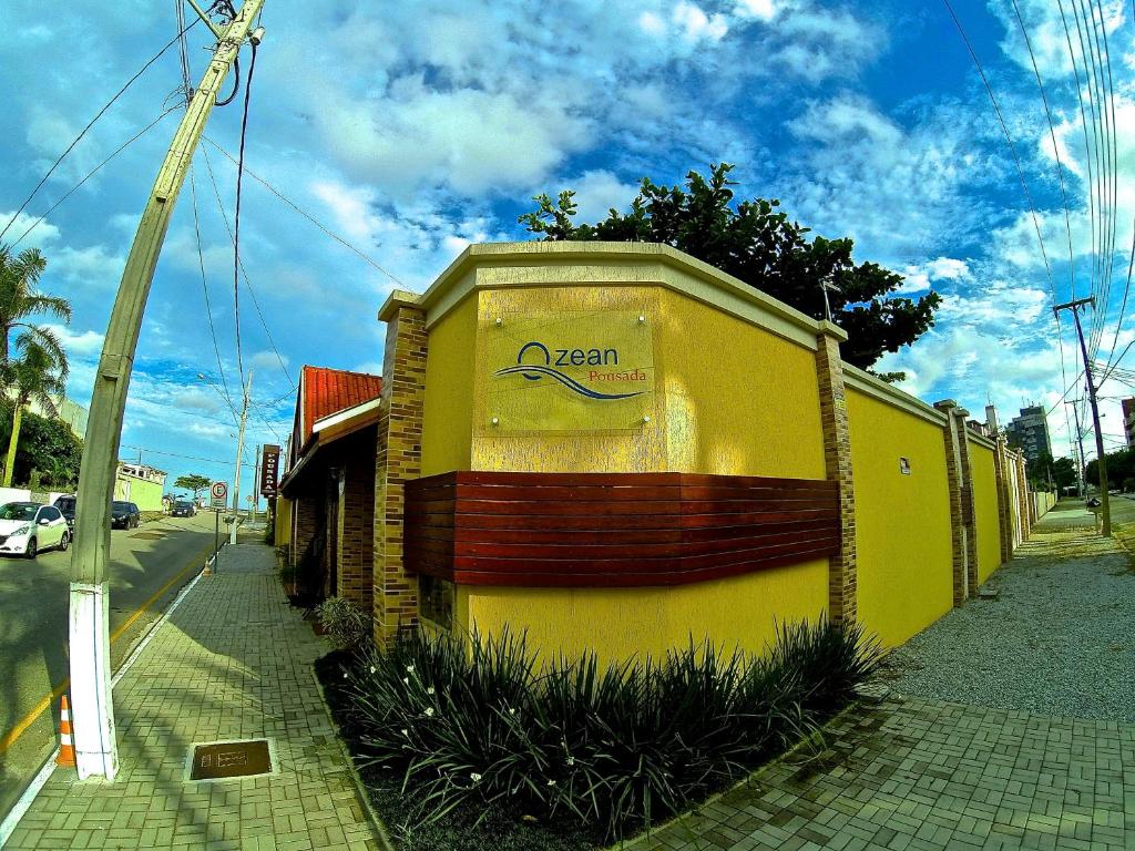 a yellow building with a sign on the side of it at Pousada Ozean in Matinhos