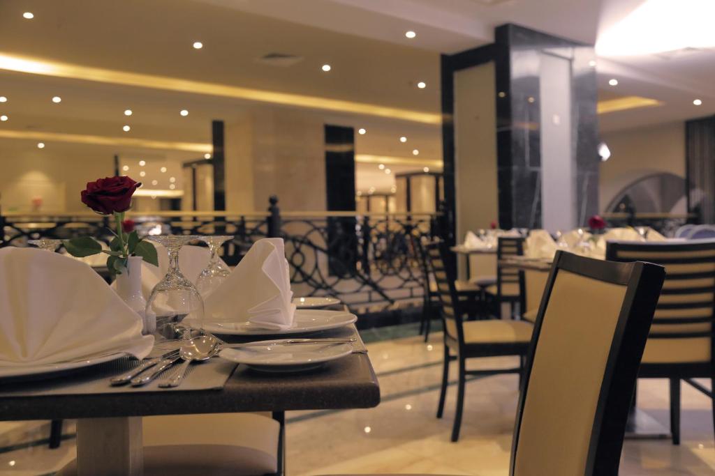 a dining room with a table with plates and napkins at Saja Al Madinah in Al Madinah