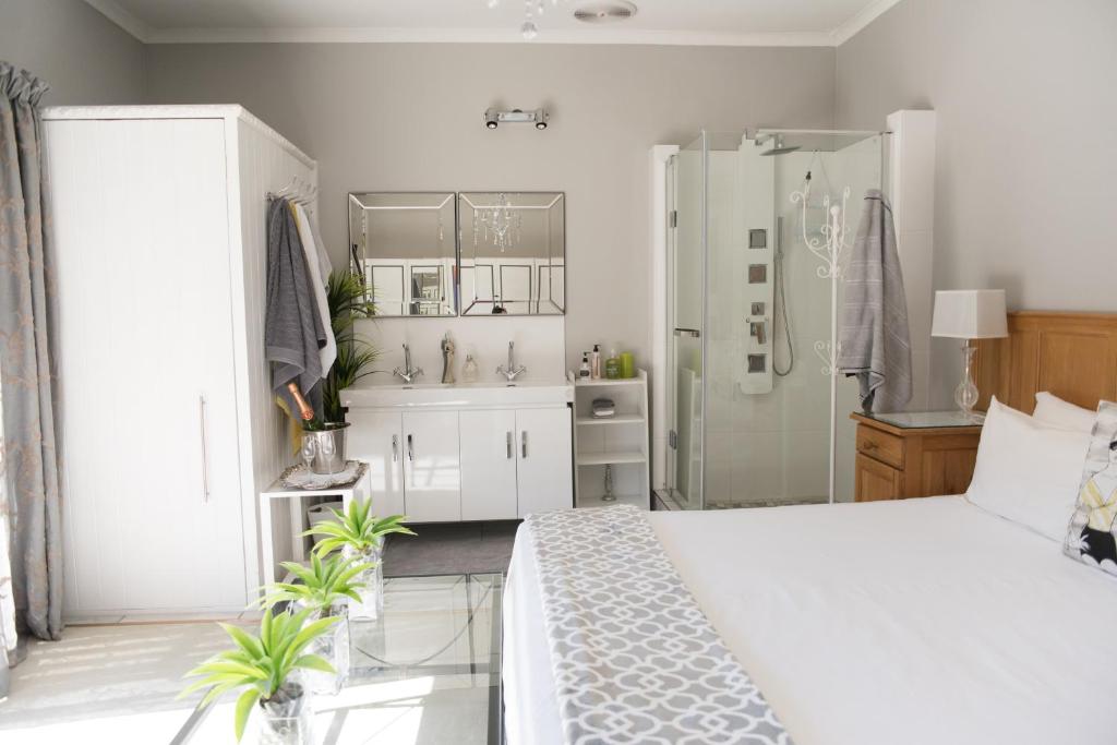 a bedroom with a white bed and a bathroom at Gate 66 in Somerset East