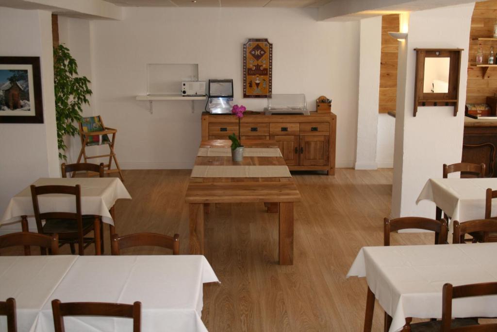 a dining room with tables and chairs and a kitchen at Adonis Le Chastellan in Valberg