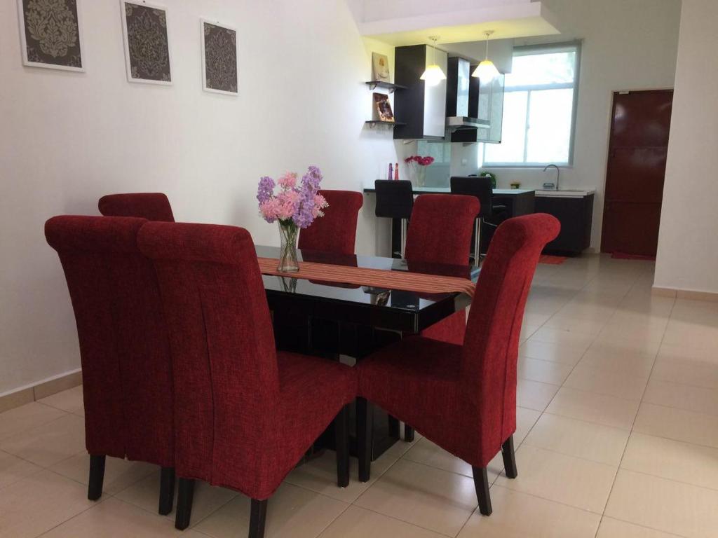 a dining room with a table and red chairs at Homestay As SyifaMuslimOnly Changlun in Changlun