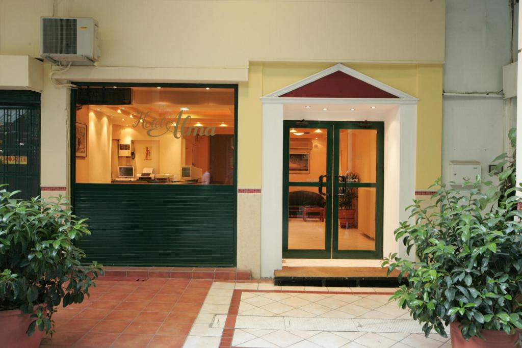 una entrada a un edificio con una puerta verde en Alma, en Atenas