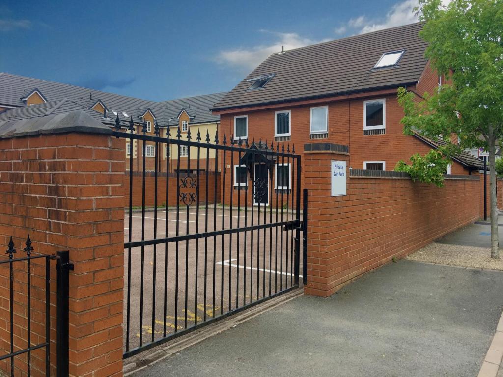 une clôture en fer forgé devant une maison dans l'établissement Phoenix House Apartments, à Walsall