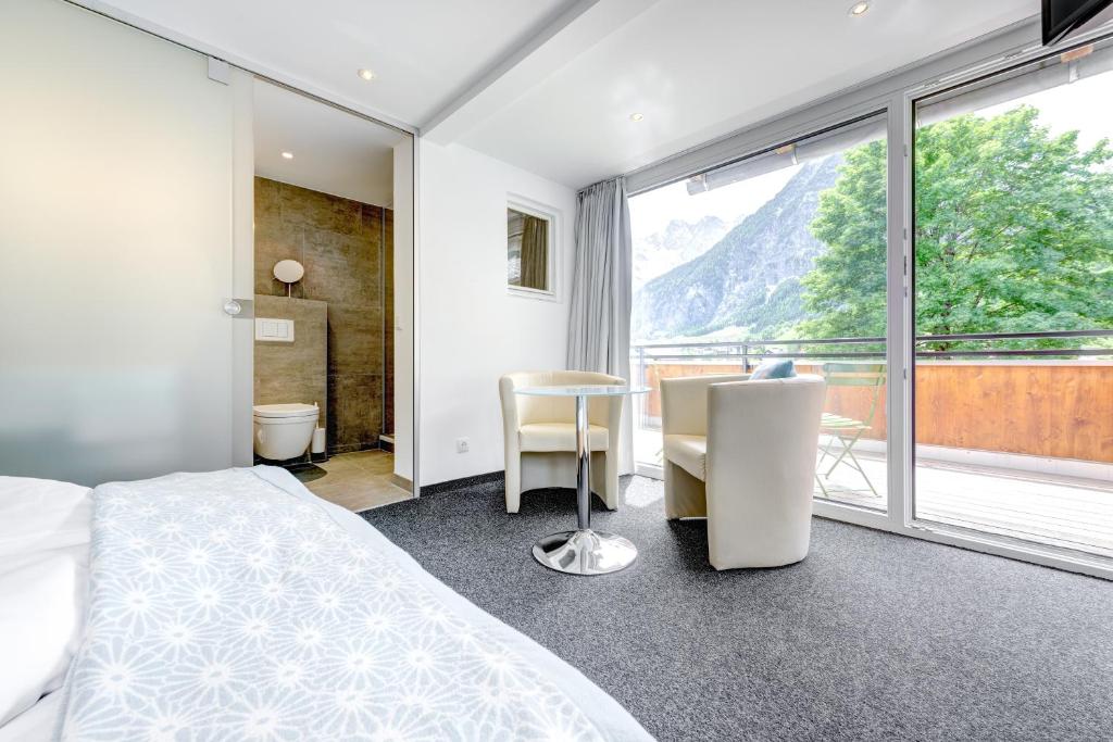 ein Schlafzimmer mit einem Bett und einem Tisch und einem Fenster in der Unterkunft Hotel Lün in Brand