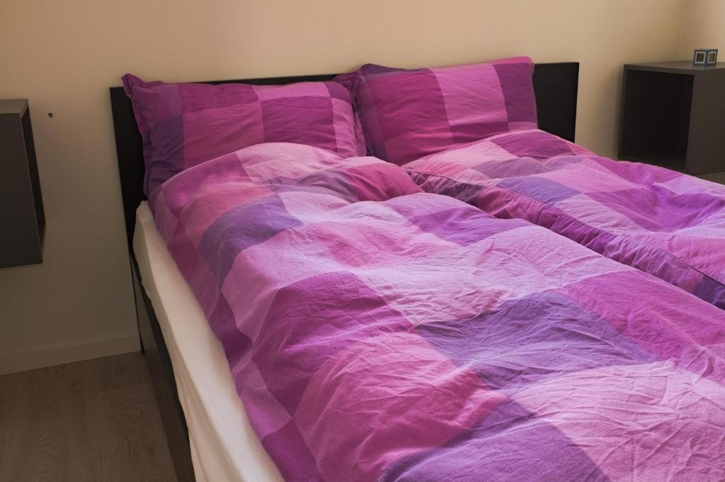 a bed with a purple comforter in a room at Apartment Ulsteinvik in Ulsteinvik