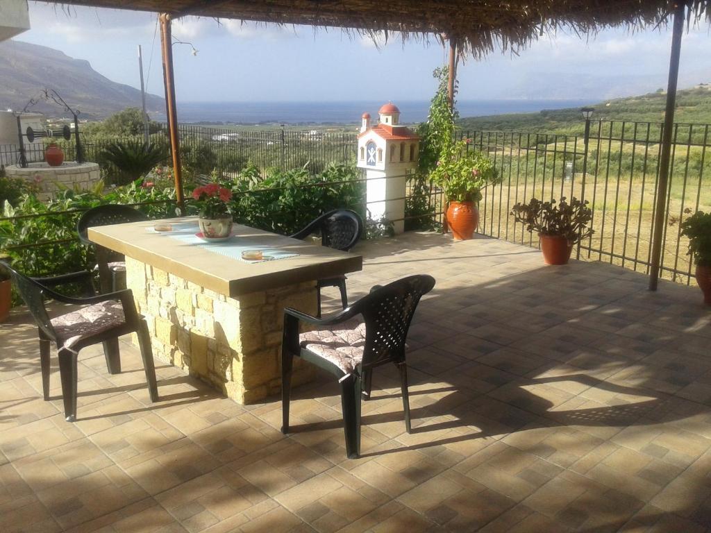 Gramvousa's Filoxenia Apartment في كيساموس: طاولة وكراسي على فناء مع اطلالة