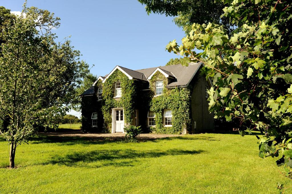 una casa grande con un patio de hierba delante de ella en Homeplace Retreat Bellaghy Top Rated Property for Families Min 2 nights, en Bellaghy