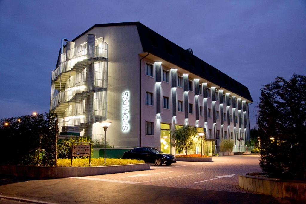 a building with a car parked in front of it at Hotel Sporting Cologno in Cologno Monzese