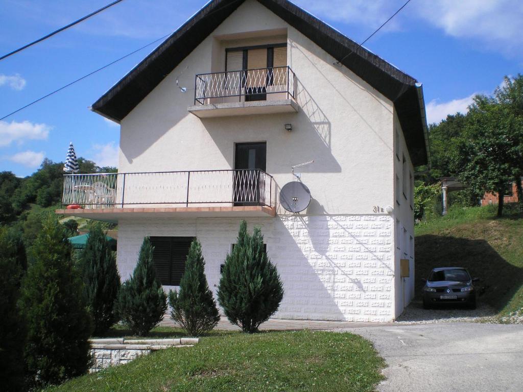 ein weißes Haus mit einem Balkon an der Seite in der Unterkunft Apartments Country House Stipica in Tuheljske Toplice