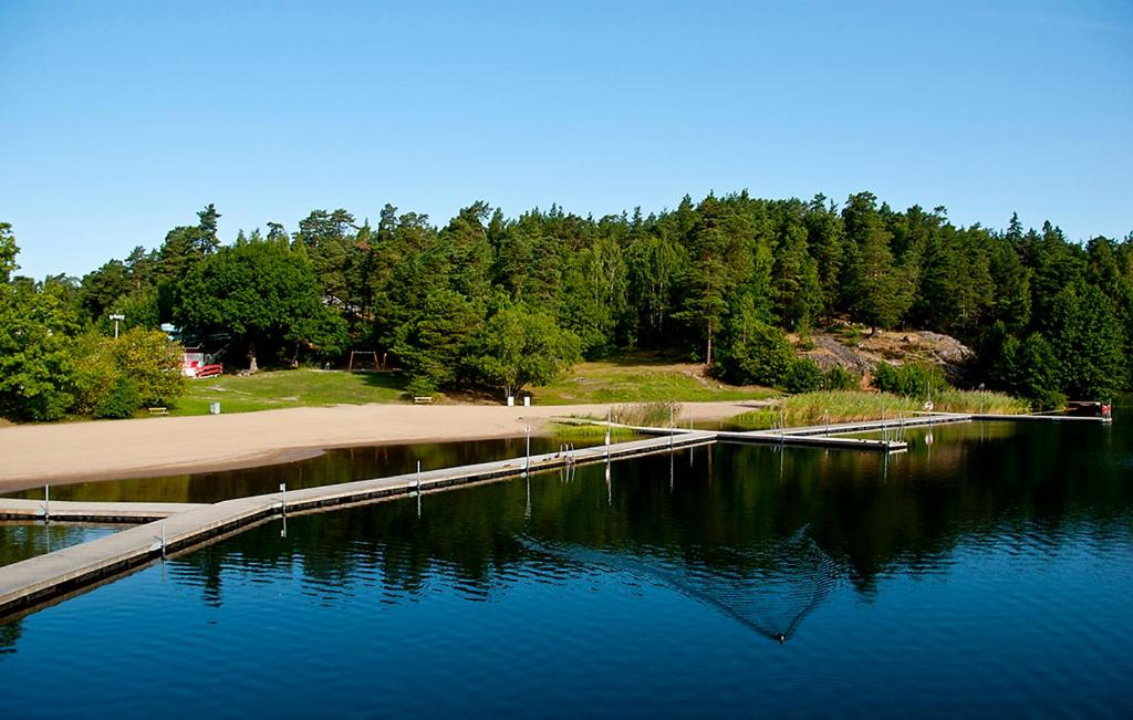 una masa de agua con un muelle en el medio en Rösjöbaden Camping & Stugby en Sollentuna