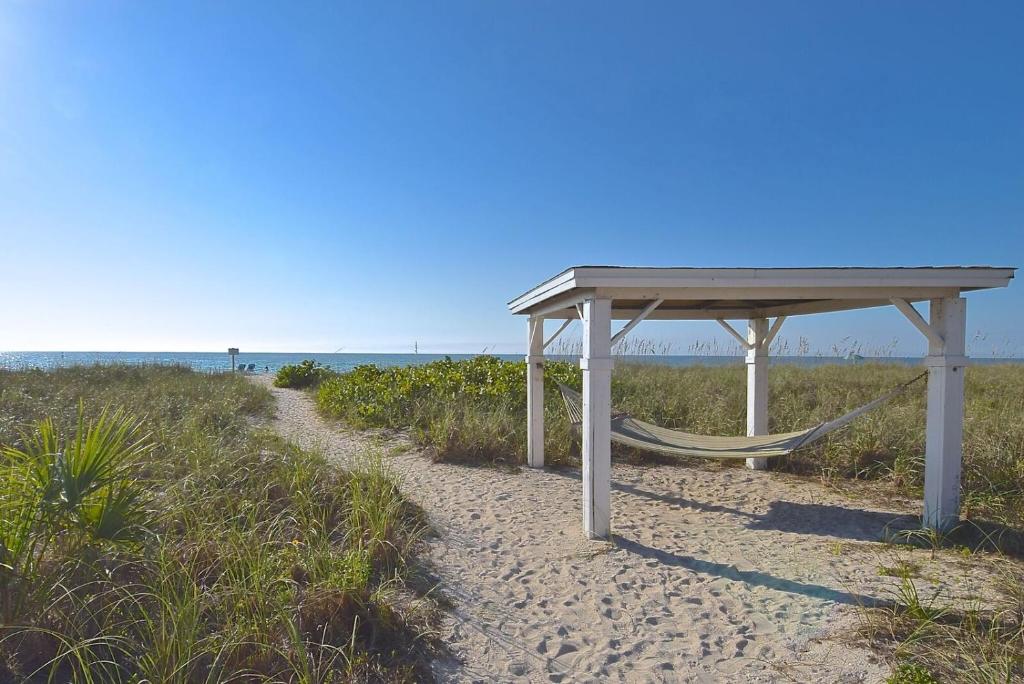 a picnic table and a hammock on the beach at A Beach Retreat on Casey Key in Venice