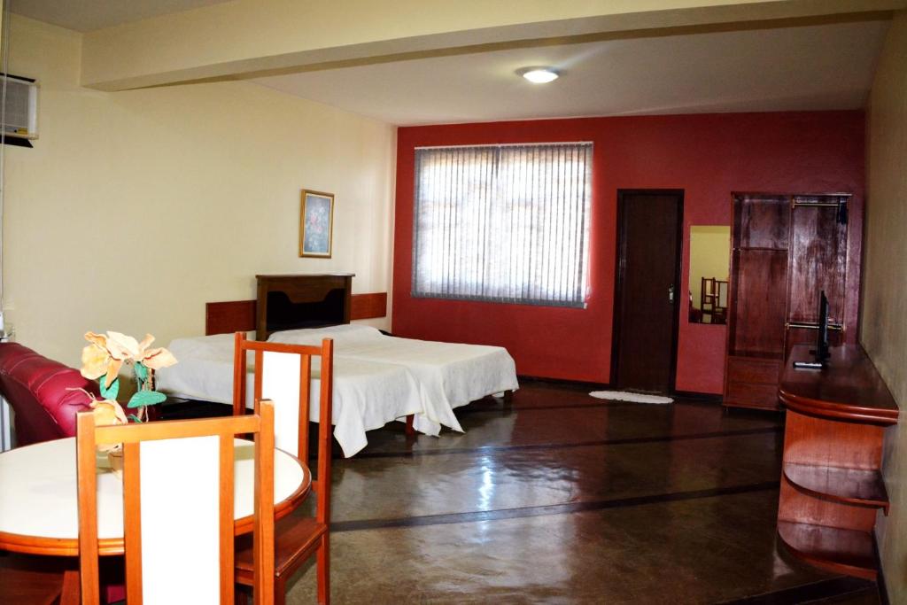 a bedroom with a bed and a red wall at Ana Maria Apart Hotel in Arcos