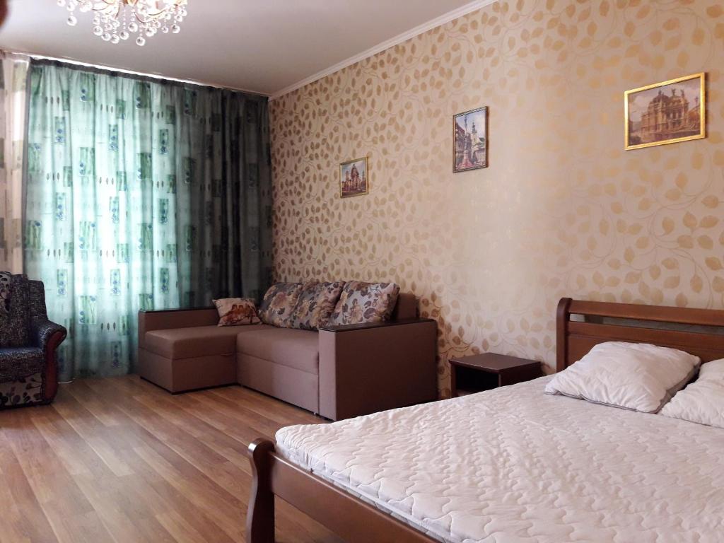 リヴィウにあるApartments on Virmenska Streetのベッドルーム1室(ベッド1台、ソファ、シャンデリア付)